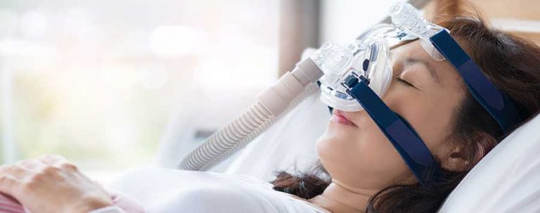 A woman sleeping with a CPAP machine on