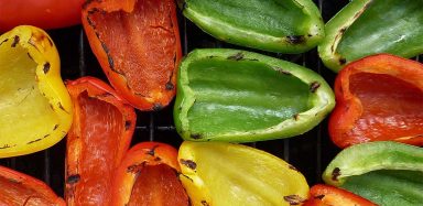 Yellow, red and green peppers on a grill.