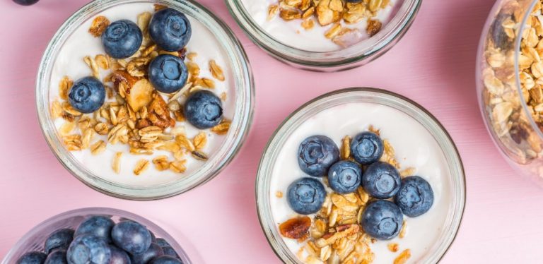 Bowls of yogurt with granola and blueberries on top